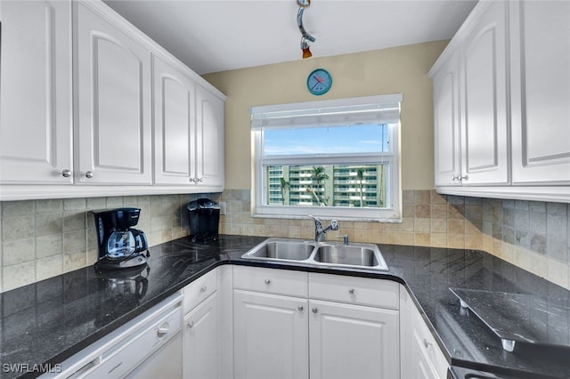 kitchen featuring tasteful backsplash, white cabinetry, sink, and white dishwasher