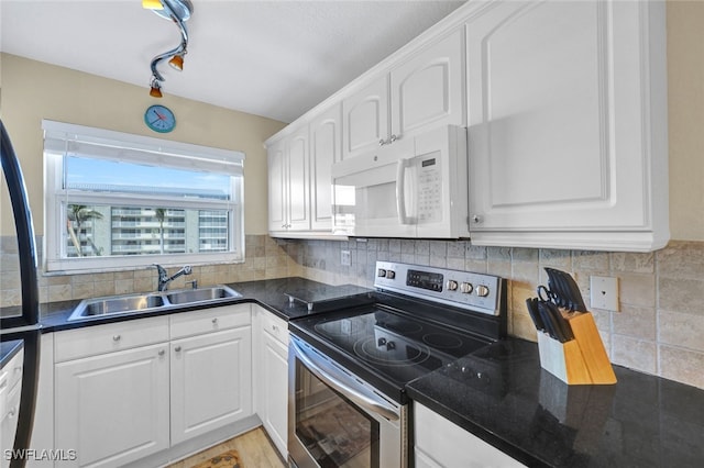 kitchen with electric stove, sink, white cabinetry, and tasteful backsplash