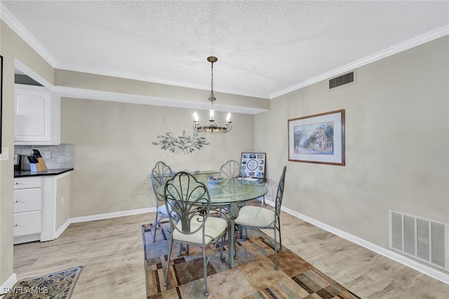 dining space with ornamental molding, a chandelier, and light wood-type flooring