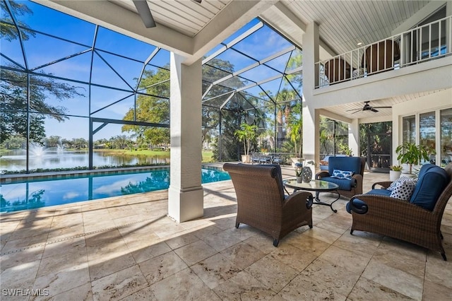 view of patio with a water view, ceiling fan, an outdoor hangout area, and glass enclosure