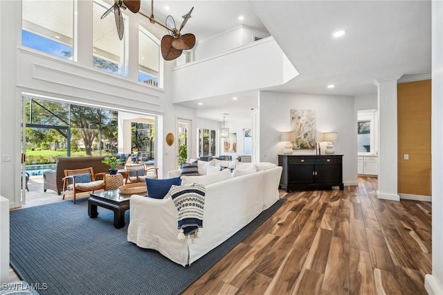 living room with a towering ceiling and hardwood / wood-style floors