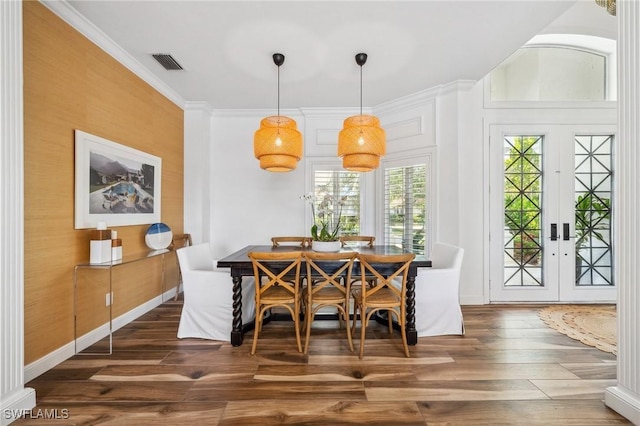 dining area featuring dark hardwood / wood-style flooring, ornamental molding, and french doors