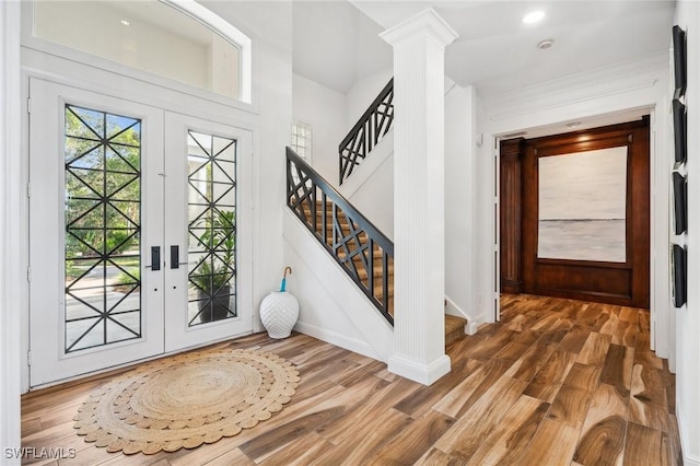 entryway with french doors, dark hardwood / wood-style floors, and ornate columns