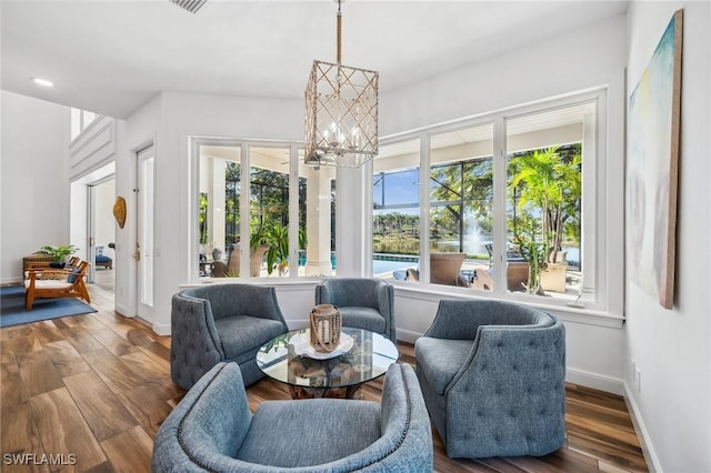 sunroom / solarium featuring plenty of natural light and a notable chandelier