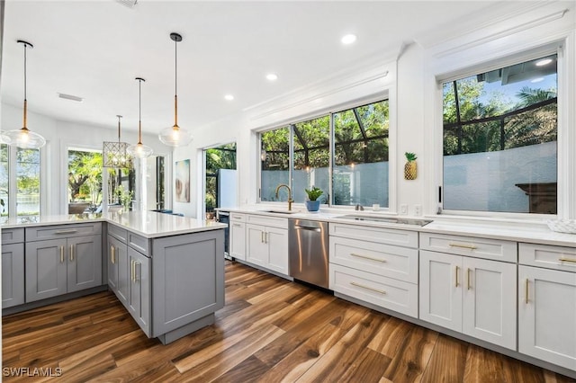 kitchen featuring sink, dishwasher, gray cabinetry, hanging light fixtures, and dark hardwood / wood-style flooring