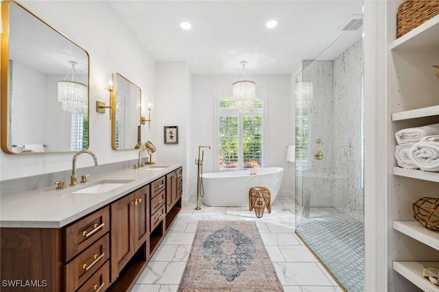 bathroom featuring vanity, a notable chandelier, and separate shower and tub