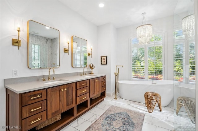 bathroom with vanity, a notable chandelier, and a bathing tub