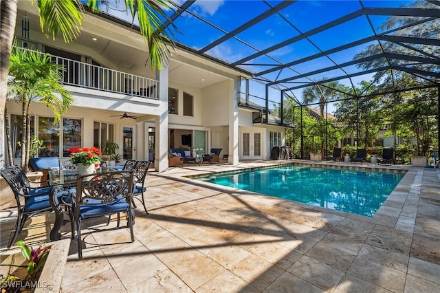 view of pool with french doors, ceiling fan, a lanai, and a patio area