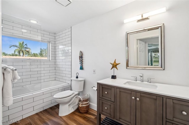 full bathroom featuring vanity, tiled shower / bath combo, wood-type flooring, and toilet