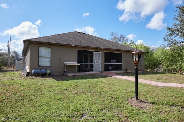 rear view of property featuring a sunroom and a lawn