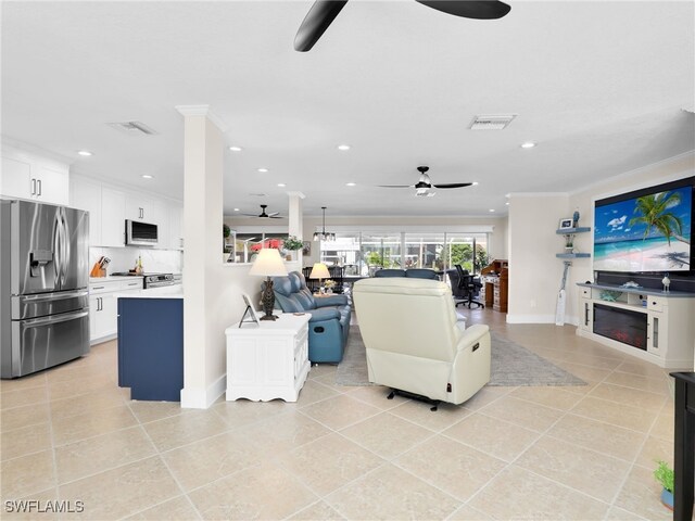 living room with light tile patterned flooring, ceiling fan, and ornamental molding