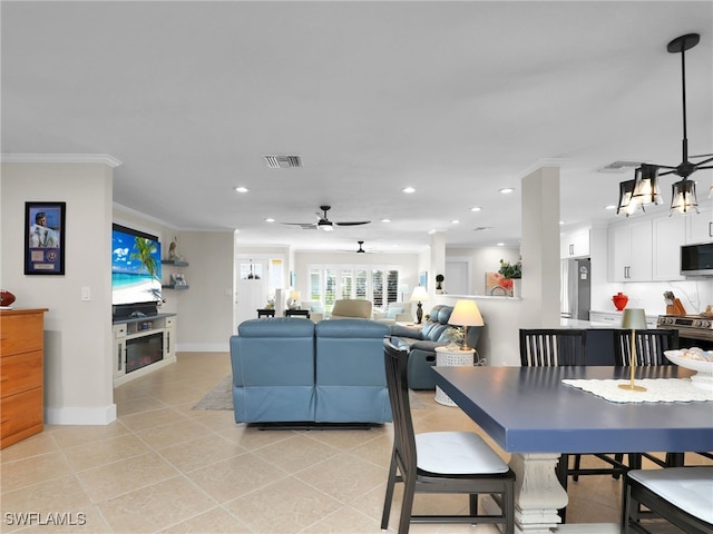 tiled dining area featuring crown molding and ceiling fan