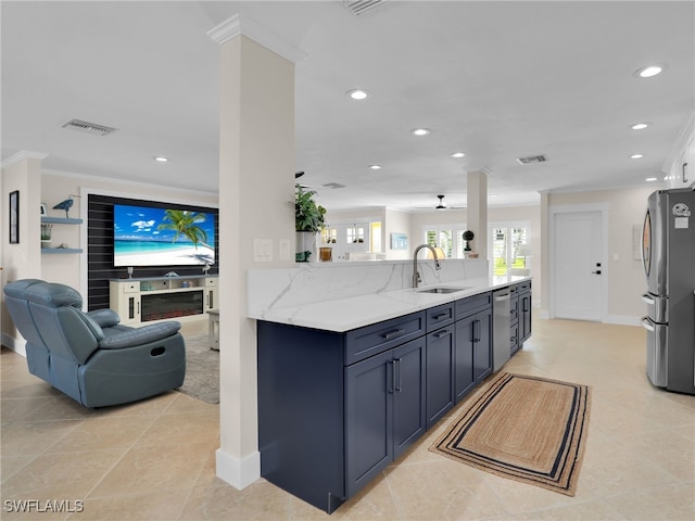 kitchen featuring appliances with stainless steel finishes, sink, light stone counters, kitchen peninsula, and crown molding