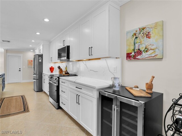 kitchen with light stone countertops, decorative backsplash, stainless steel appliances, and white cabinets