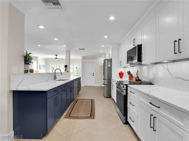 kitchen featuring stainless steel appliances, white cabinetry, light stone countertops, and backsplash