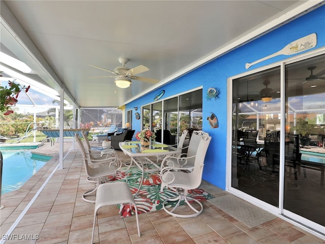 view of patio featuring ceiling fan and glass enclosure