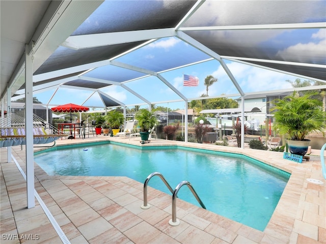 view of pool with a patio and glass enclosure