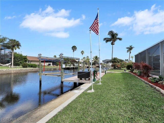 dock area with a water view, glass enclosure, and a lawn