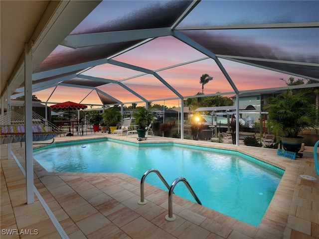 outdoor pool featuring glass enclosure and a patio area