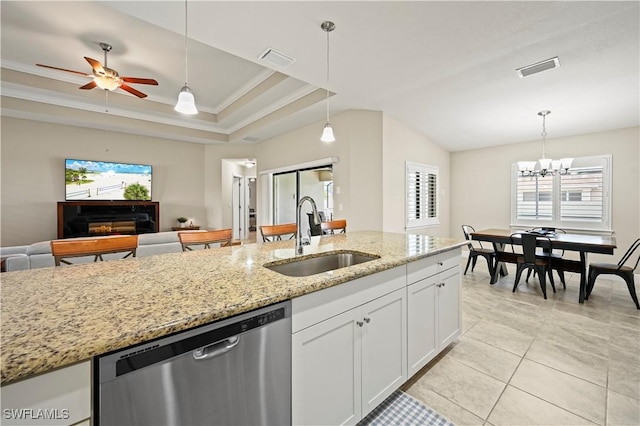 kitchen featuring pendant lighting, white cabinetry, sink, stainless steel dishwasher, and light stone counters