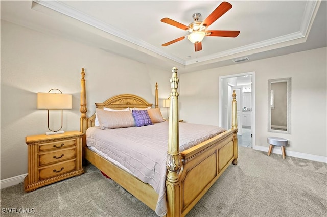 carpeted bedroom featuring crown molding, ensuite bathroom, ceiling fan, and a tray ceiling