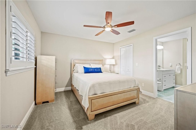 bedroom with ceiling fan, connected bathroom, carpet flooring, and a closet