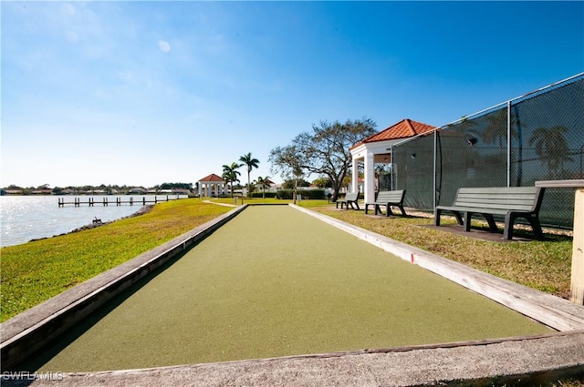 view of property's community with a water view and a yard