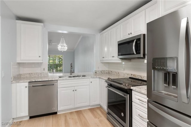 kitchen with sink, stainless steel appliances, white cabinets, and light stone countertops