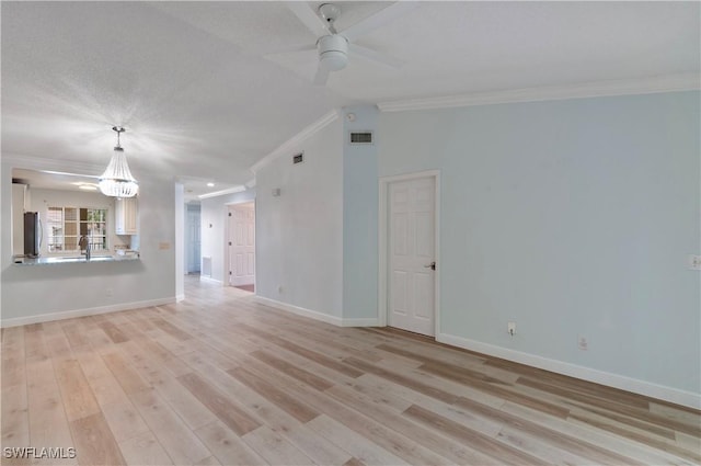 unfurnished living room with lofted ceiling, sink, ceiling fan, crown molding, and light wood-type flooring