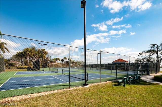 view of tennis court featuring a lawn