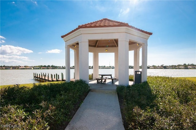 surrounding community with a gazebo, a water view, and a dock