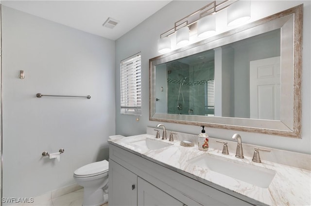 bathroom with vanity, toilet, and a shower with door