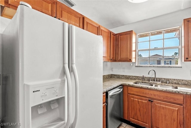 kitchen with stainless steel dishwasher, sink, and white fridge with ice dispenser