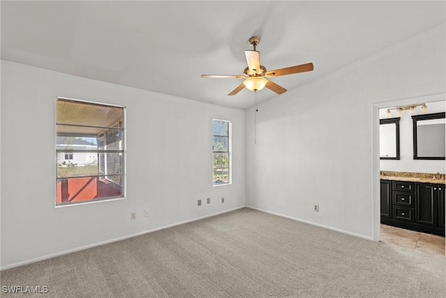 unfurnished bedroom with ceiling fan, connected bathroom, and light carpet