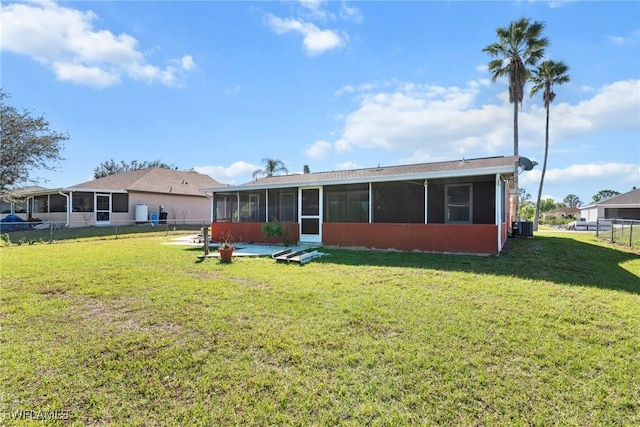 rear view of property with a yard, a sunroom, and central air condition unit