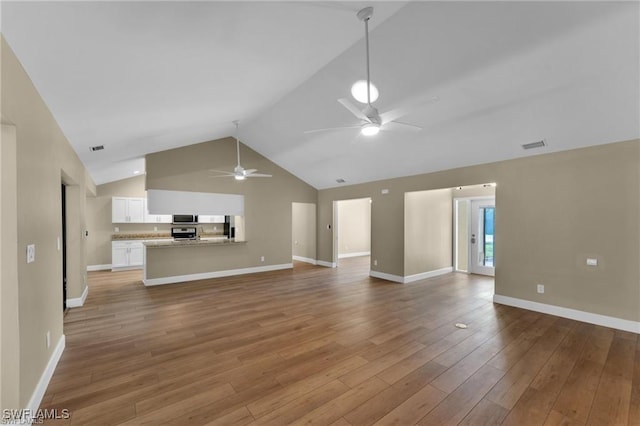 unfurnished living room featuring hardwood / wood-style flooring, ceiling fan, and vaulted ceiling