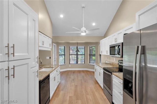 kitchen with sink, light hardwood / wood-style flooring, stainless steel appliances, light stone countertops, and white cabinets