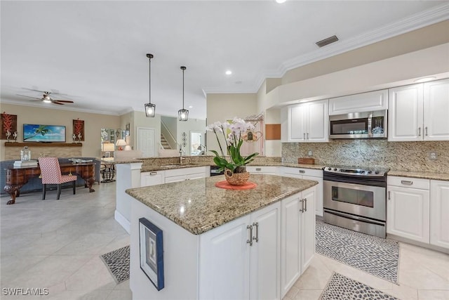 kitchen featuring pendant lighting, appliances with stainless steel finishes, a center island, and white cabinets