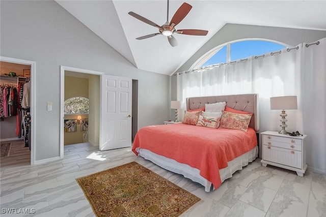 bedroom with a walk in closet, high vaulted ceiling, a closet, and ceiling fan