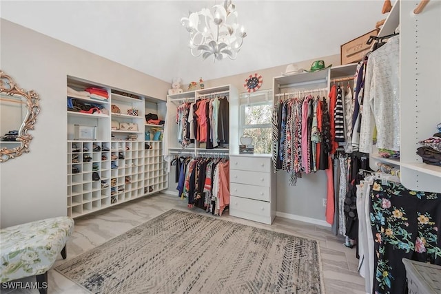 spacious closet featuring a notable chandelier