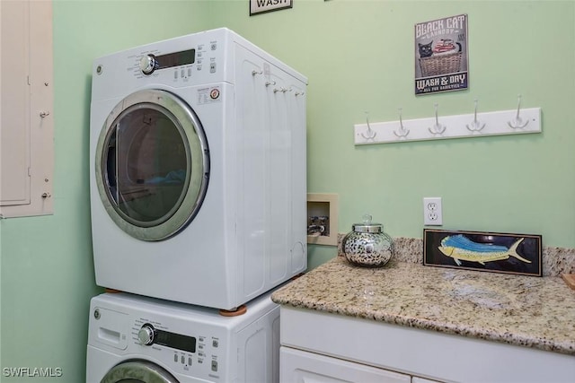 clothes washing area featuring stacked washer and clothes dryer