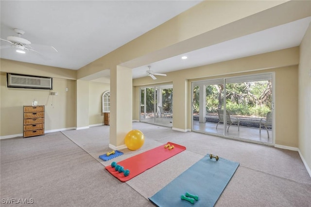 workout room featuring ceiling fan, carpet, and a wall unit AC