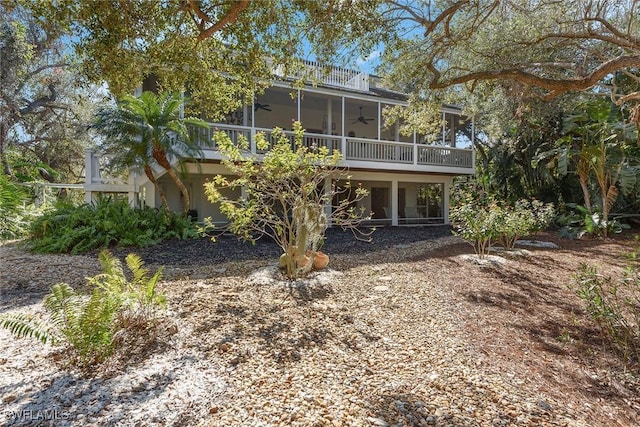 back of house featuring a balcony and ceiling fan