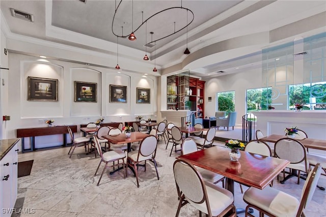 dining area featuring a raised ceiling and crown molding