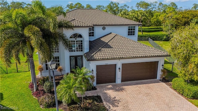 mediterranean / spanish-style home featuring a garage, a front yard, and french doors