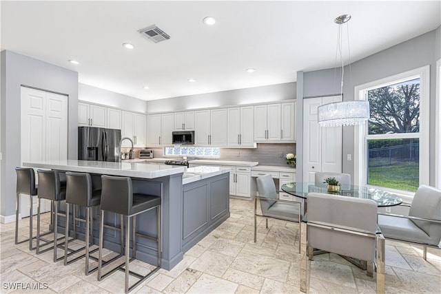 1801 Senegal Date Dr, Naples, FL 34119 - kitchen with appliances with stainless steel finishes, stone tile flooring, tasteful backsplash, white cabinets, and recessed lighting