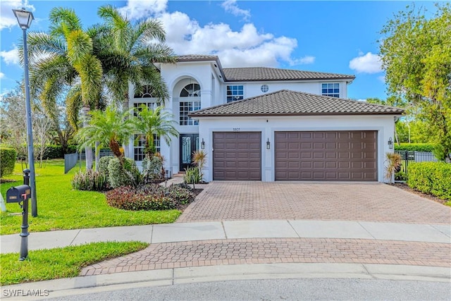 1801 Senegal Date Dr, Naples, FL 34119 - mediterranean / spanish-style house with decorative driveway, an attached garage, stucco siding, and a front yard