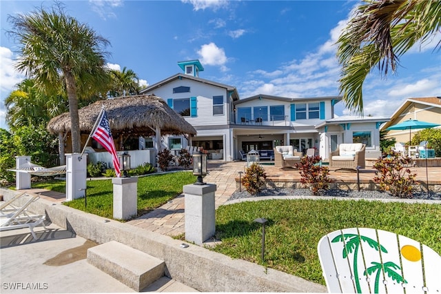 rear view of property featuring a patio area, a balcony, an outdoor living space, and fence