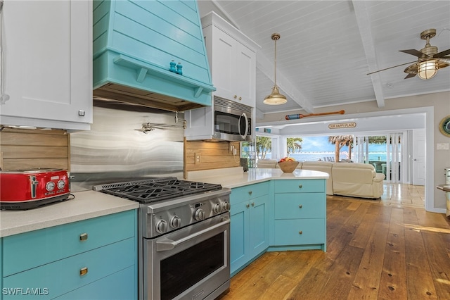 kitchen with hardwood / wood-style floors, white cabinetry, stainless steel appliances, and beam ceiling