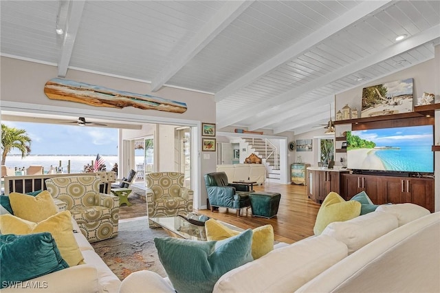 living room featuring lofted ceiling with beams, ceiling fan, wood finished floors, and stairs